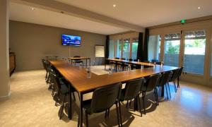 a large conference room with a long table and chairs at Logis Hôtel Médiéval, Montélimar Nord in Rochemaure
