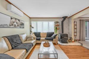 a living room with a couch and a fireplace at Spa Game room Waterfront - Le Refuge Vert in Brébeuf