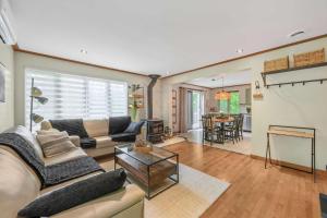 a living room with a couch and a table at Spa Game room Waterfront - Le Refuge Vert in Brébeuf +59 photos