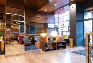 a lobby of a salon with chairs and tables at Wyndham Cluj in Cluj-Napoca