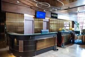 a restaurant with a bar with a tv above it at Wyndham Cluj in Cluj-Napoca
