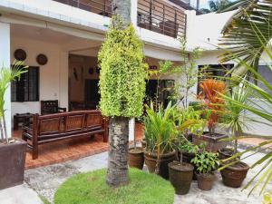 a house with plants and a bench in front of it at Sanctuary Transient House Bacolod in Bacolod