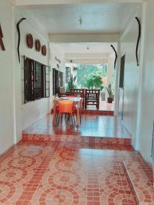 a dining room with a table and chairs on a tiled floor at Sanctuary Transient House Bacolod in Bacolod