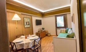 a living room with a table and a couch at Il Nido di Kora in Pescasseroli