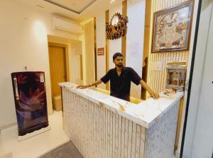 a man standing at a counter in a room at Hotel Shree krishna in Ujjain +10 photos