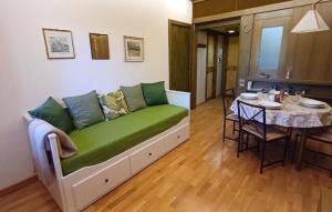 a living room with a green couch and a table at Il Nido di Kora in Pescasseroli