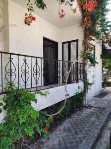 a balcony of a house with flowers on it at Dream house steps from sea in Pídima Kyrás