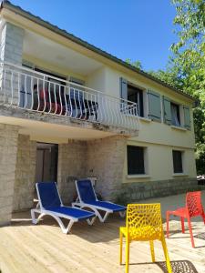 a group of chairs on a deck with a balcony at Lénola en Ardèche in Labeaume