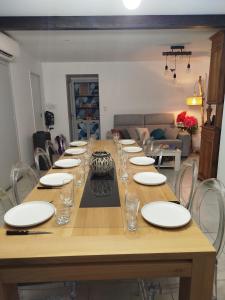 a long wooden table with plates and glasses on it at Lénola en Ardèche in Labeaume +29 photos