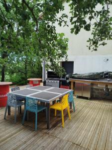 a ping pong table and chairs on a deck at Lénola en Ardèche in Labeaume