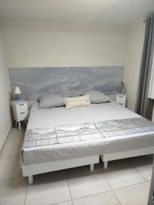 a white bed in a room with the ocean at Lénola en Ardèche in Labeaume