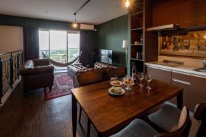a kitchen and living room with a table and chairs at Hillside Sea View Resort Villa Gushikumui in Motobu