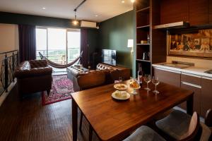 a living room with a wooden table and chairs at Hillside Sea View Resort Villa Gushikumui in Motobu