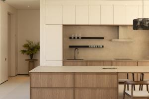 a kitchen with white cabinets and a counter with chairs at KW3 Villas in Mae Nam