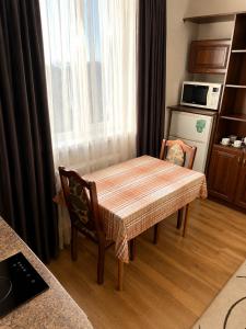 ein Tisch und ein Stuhl in einem Raum mit Küche in der Unterkunft Готель ВІОЛІТІ in Chmelnyzkyj