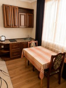 eine Küche mit Tisch, Spüle und Fenster in der Unterkunft Готель ВІОЛІТІ in Chmelnyzkyj