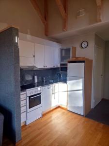 a kitchen with white appliances and a wooden floor at Kylpyla SPA, Saimaa Villa B3 in Imatra +14 photos