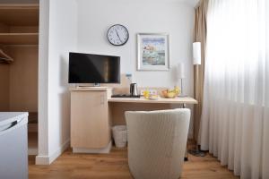 a room with a desk with a computer and a clock at Schöne Apartments I Kostenloses Parken I home2share in Münster