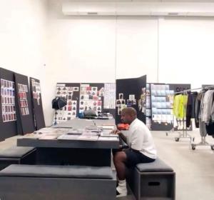 a man sitting at a desk in a clothing store at Eliot Oviasogie in Benin City