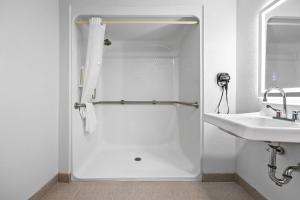 a white bathroom with a shower and a sink at Clarion Pointe Springfield Southeast in Springfield +62 photos