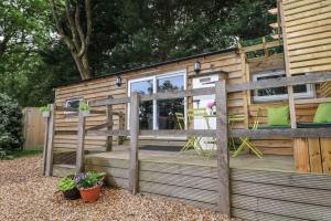 a tiny house with a fence and a deck at Harvest Lodge in Haywards Heath +9 photos