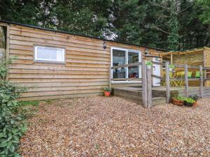 a log cabin with a porch and a deck at Harvest Lodge in Haywards Heath