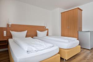two beds in a room with white sheets at Schöne Apartments I Kostenloses Parken I home2share in Münster +115 photos