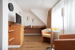 a hotel room with a table and a tv at Schöne Apartments I Kostenloses Parken I home2share in Münster