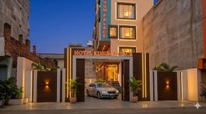 a car is parked in front of a building at Hotel Kusum Palace in Gaya