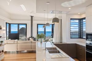 a kitchen and living room with a couch at Perfectly Pambula in Pambula Beach