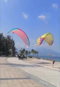 two kites flying in the sky on a beach at Perla Home in Danang