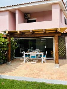 a patio with a table and chairs in a house at Casa Vacanza Li Menduli San Teodoro in San Teodoro