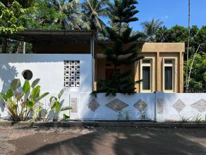 a house with a blue and white wall at Sanghiang Homestay in Batukaras