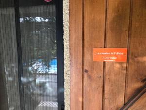a sign on the door of a wooden building at La chambre d'hôtes de l'olivier Gîte A Coeur Vaillant in Vailhan