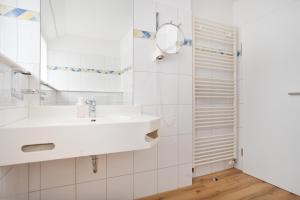 a white bathroom with a sink and a mirror at Schöne Apartments I Kostenloses Parken I home2share in Münster