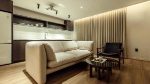 a living room with a couch and a chair at Anook Stay Daejeon Daeheung in Daejeon
