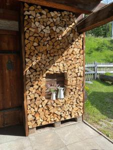 a fireplace made out of a pile of fire wood at Carolina Gatekeeper's House in Zernez +37 photos