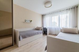a bedroom with two beds and a mirror at VakarDi Apartments in Šiauliai