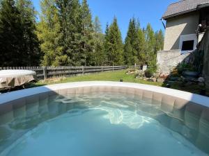 a large swimming pool with blue water in a backyard at Carolina Gatekeeper's House in Zernez