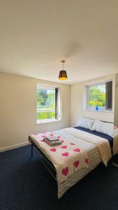 a bedroom with a bed with red hearts on it at Bambi Nest in Sketty