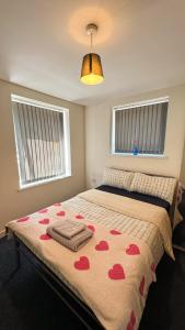a bedroom with a bed with red hearts on it at Bambi Nest in Sketty +1 photo