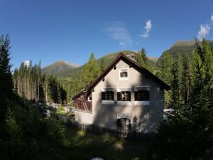 a white house with mountains in the background at Carolina Gatekeeper's House in Zernez