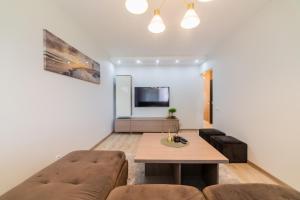 a living room with a couch and a table at VakarDi Apartments in Šiauliai