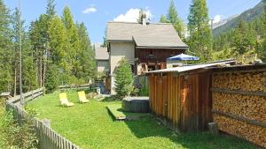 a backyard with a fence and a house at Carolina Gatekeeper's House in Zernez