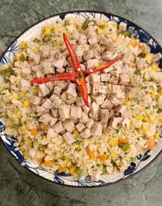 a plate of food with chicken and rice at Perla Home in Danang