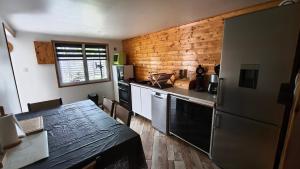 a kitchen with a refrigerator and a table in it at Maison chaleureuse avec parking gratuit sur place in Coulogne