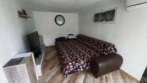 a bedroom with a bed and a clock on the wall at Maison chaleureuse avec parking gratuit sur place in Coulogne