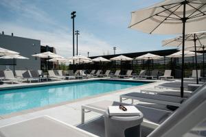a swimming pool with chairs and umbrellas on a building at Omni Viking Lakes in Eagan