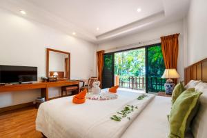 a bedroom with a large white bed with orange pillows at Sailom Resort Bangsaphan in Bang Saphan +65 photos