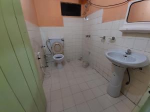 a bathroom with a toilet and a sink at Sanara Hotel in Nuwara Eliya
